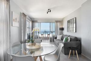 a living room with a glass table and a couch at Ocean View 503 in Bloubergstrand