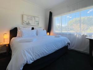 1 dormitorio con 1 cama grande y ventana grande en The Alice, Mittagong, en Mittagong