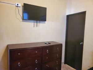 a dresser with a flat screen tv on a wall at Del Valle Central Casa near Trendy Calle Loiza- One bedroom with queen in San Juan