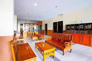 a living room with couches and chairs and a table at OYO 91415 De Wijaya Hotel in Bungurasih
