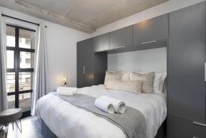 1 dormitorio con 1 cama grande y 2 toallas. en Manhattan on Coral 7 en Bloubergstrand