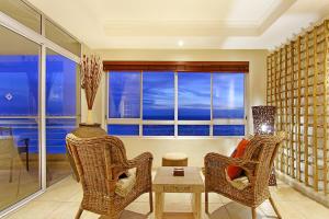- un salon avec des chaises, une table et une fenêtre dans l'établissement Ocean View C602 by HostAgents, à Bloubergstrand