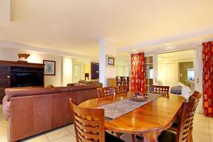 un salon avec une table en bois et un canapé dans l'établissement Ocean View C602 by Host Agents, à Bloubergstrand