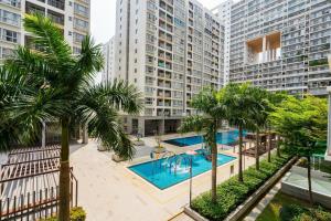 an apartment complex with a swimming pool and palm trees at Lee's apartment at Scenicvalley in Ho Chi Minh City