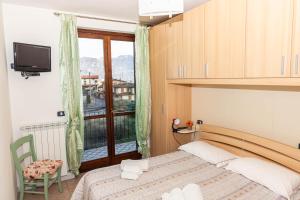 um quarto com uma cama e uma grande janela em La casa di Gabry in residence con piscina comune em Tavernola Bergamasca