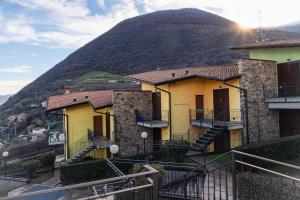 um edifício com escadas em frente a uma montanha em La casa di Gabry in residence con piscina comune em Tavernola Bergamasca