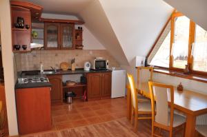 a kitchen with a table and a kitchen with a dining room at Apartmán pod Veľkou Račou in Čadca