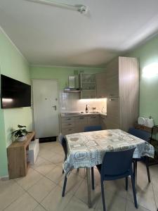 una cucina con tavolo e sedie in una stanza di Bilocale con giardino a Marina di Grosseto