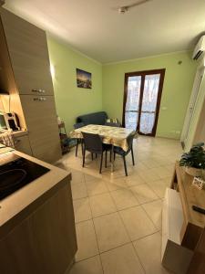 una cucina e un soggiorno con tavolo e sedie di Bilocale con giardino a Marina di Grosseto