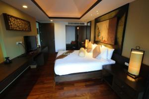 a hotel room with a bed and a television at Niramaya Villa & Wellness in Ko Yao Noi