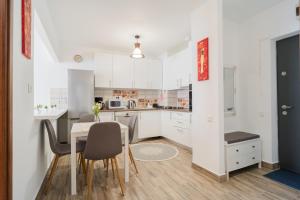a kitchen with white cabinets and a table and chairs at Renovated Gem Plumbuita Park in Bucharest +36 photos