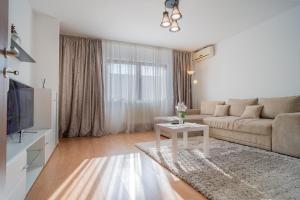 a living room with a couch and a table at Renovated Gem Plumbuita Park in Bucharest