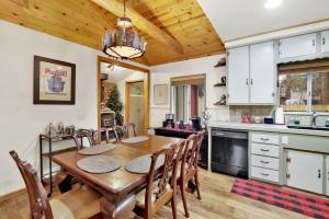 uma cozinha e sala de jantar com uma mesa de madeira e cadeiras em 2417-Timber Pines Chalet cabin em Big Bear Lake