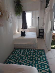 a bedroom with two beds and a rug at Cliff Cottage in Ko Chang
