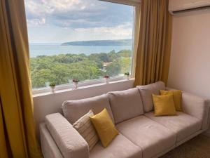 a living room with a couch and a large window at Unique Sea View in Varna City
