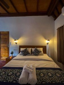1 dormitorio con 1 cama grande y 2 pares de calcetines en TM DARTA Homestay UBUD, en Ubud