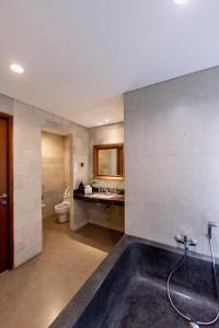 a bathroom with a bath tub and a toilet at Anumana Ubud Hotel in Ubud
