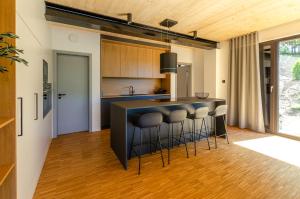 a kitchen with a black counter and stools at Sauerland Lodge - Haus X in Winterberg