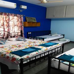 three beds in a room with blue walls at Konnectify Quintuple - 5 Person Room Suite in Coimbatore