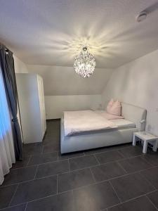 a small bedroom with a bed and a chandelier at Ferienwohnung Jodis in Bonerath