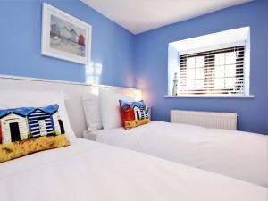 two beds in a bedroom with blue walls at 2 Bed in Bude DBANK in Holsworthy