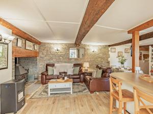 a living room with leather furniture and a stone wall at 2 Bed in Glastonbury MOORH in Edington