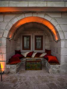 a room with several pillows in a stone wall at Lost City Cappadocia Cave Hotel in Nar