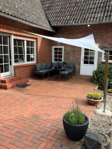 a patio with a couch and a white canopy at Schicke Ferienwohnung im Wendland 