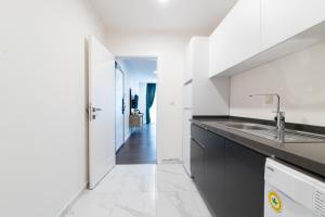 a white kitchen with a sink and a hallway at Sabırlar City Suites Hotel in Trabzon