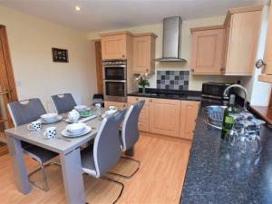 a kitchen with a table and chairs and a kitchen with a sink at 2 Bed in Looe LANDC in Duloe