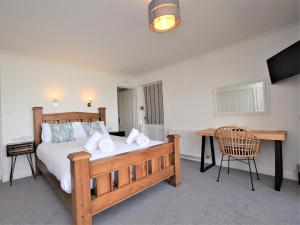 um quarto com uma cama de madeira e uma secretária em 3 Bed in Appledore WATER em Appledore