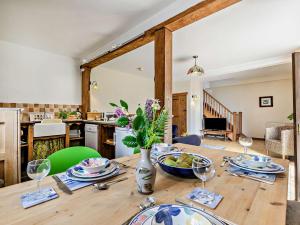 a dining room table with a vase of flowers on it at 2 Bed in Crackington Haven 02038 in North Petherwin