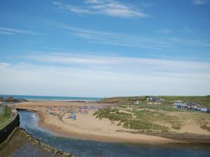 a group of people on a beach next to a river at 3 Bed in Bude NPOAK in Poundstock