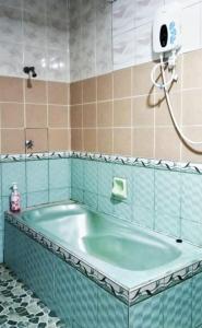uma banheira na casa de banho com um chuveiro em Kakmas Homestay em Papar