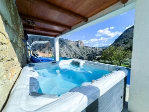 a hot tub with a view of a mountain at Heated Private Ozone Salt Pool, Jacuzzi, Cinema, Ping Pong, Billiard, Ps5, Playground, Big Chess - Villa Rokka Luxe in Kissamos