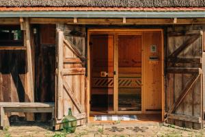 an open door of a building with wooden doors at Pommernhaus Forsthaus Rieth am See, Sauna, Kamin, Ruderboot in Rieth