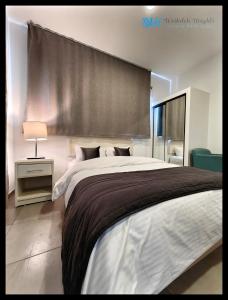 um quarto com uma cama grande e uma janela grande em Weibdeh Heights Apartments em Amã