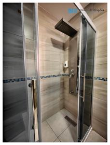 a shower with a glass door in a bathroom at Weibdeh Heights Apartments in Amman