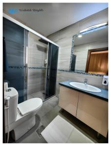 e bagno con servizi igienici, lavandino e doccia. di Weibdeh Heights Apartments ad Amman