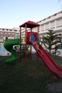 zwei Kinder spielen auf einer Rutsche auf einem Spielplatz in der Unterkunft white lilyum hotel in Antalya