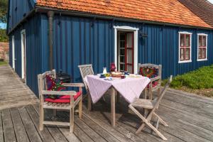 une table et des chaises sur une terrasse avec un bâtiment bleu dans l'établissement Pommernhaus Charmantes Colonistenhaus, Kamin, Ruderboot, 