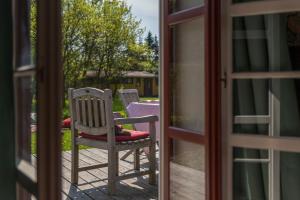 a chair sitting on a porch looking out a door at Pommernhaus Charmantes Colonistenhaus, Kamin, Ruderboot in Vorsee