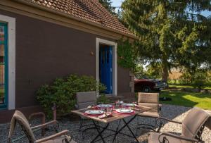 a patio with a table and chairs in front of a house at Pommernhaus Josephinenhof, Sauna, Kamin, Ruderboot in Christianshof