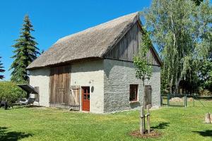 a barn with a thatched roof on a grass field at Pommernhaus Josephinenhof, Sauna, Kamin, Ruderboot in Christianshof +17 photos