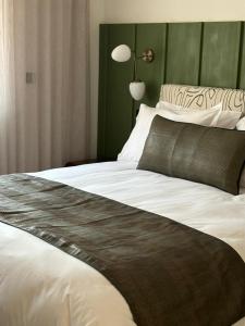 a bedroom with a large white bed with a green wall at Misk Villa - Boutique Hotel & Spa in Sidi Bou Saïd