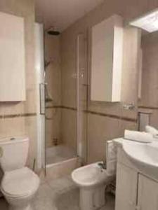 een badkamer met een toilet, een wastafel en een douche bij Le Longchamp in Deauville