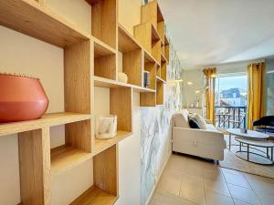 uma sala de estar com prateleiras de madeira e um sofá em Le Longchamp em Deauville