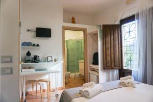sypialnia z łóżkiem i biurkiem oraz łazienka w obiekcie Casale Del Borgo w mieście San Severino