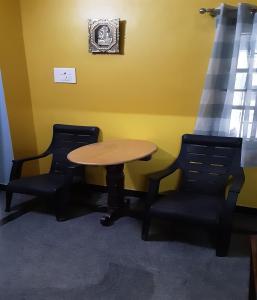 a table and two chairs in a room at Konnectify Quintuple - 5 Person Room Suite in Coimbatore