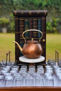 a tea kettle sitting on a table with glasses at Radisson Resort and Spa Lonavala in Lonavala